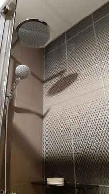 a shower in a bathroom with a shower head at Dandelion apartment in the heart of Kaunas in Kaunas
