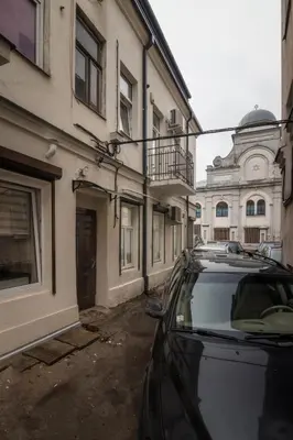 a car parked in a parking lot next to buildings at Dandelion apartment in the heart of Kaunas in Kaunas
