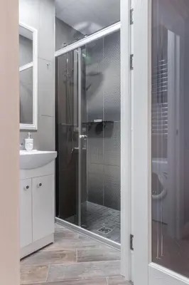 a bathroom with a shower with a glass door at Dandelion apartment in the heart of Kaunas in Kaunas