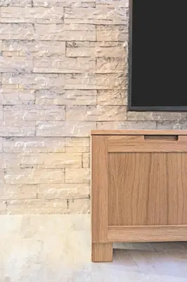 a television on a wooden cabinet in front of a brick wall at Kaunas City Center loft by URBAN RENT in Kaunas