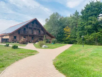 a brick path leading to a log cabin at Dzūkijos dvaro 