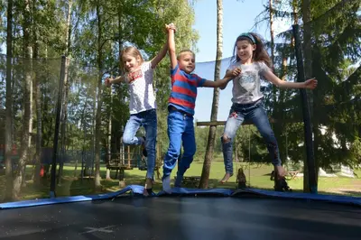 three young children jumping on a trampoline at Dzūkijos dvaro 