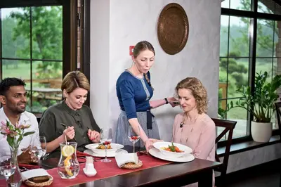 a group of people sitting at a table eating food at Dzūkijos dvaro 
