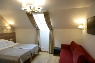 a bedroom with a bed and a window and a couch at Dzūkijos dvaro 
