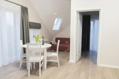 a living room with a white table and chairs at Green Hill Apartments in Kaunas