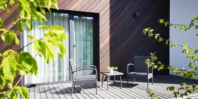 a patio with two chairs and a table on a deck at Green Hill Apartments in Kaunas