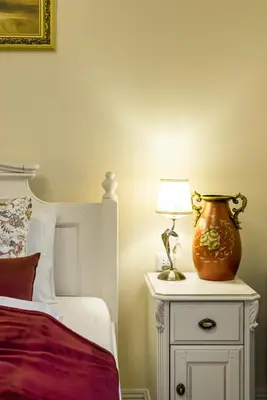 a bedroom with a bed and a vase on a night stand at HaPPy Inn Classical style, self check-in, Parking in the underground garage in Vilnius
