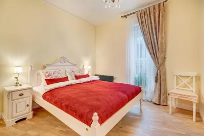 a bedroom with a large bed with a red blanket at HaPPy Inn Classical style, self check-in, Parking in the underground garage in Vilnius