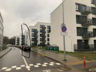 a street sign on the side of a street with buildings at Near Ozas Studio in Vilnius