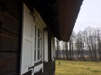 a pair of windows on the side of a log cabin at Baublys Lake Lodge in Viktarinas