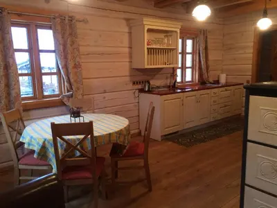 a kitchen with a table in a log cabin at Baublys Lake Lodge in Viktarinas