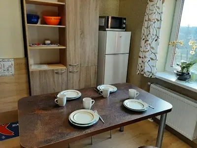 a table with plates and cups on it in a kitchen at ROOMS FOR RENT in Panevėžys
