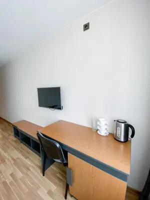 a desk in an office with a tv on a wall at 