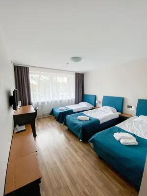 a room with three beds and a desk and a window at 
