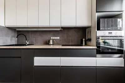 a kitchen with white cabinets and a sink at Scandinavian inspired design in Vilnius
