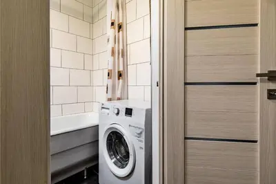 a laundry room with a washing machine and a tub at Scandinavian inspired design in Vilnius
