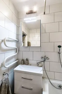 a white bathroom with a sink and a mirror at Scandinavian inspired design in Vilnius