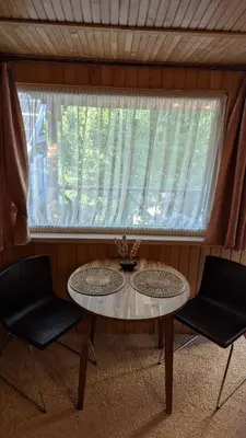 a table and two chairs in a room with a window at Namelis prie Magnolijos in Druskininkai