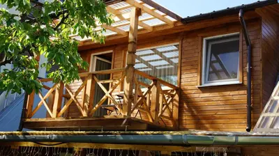 a wooden deck on the side of a house at Namelis prie Magnolijos in Druskininkai