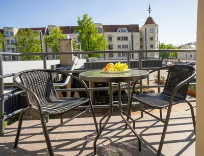 a table and chairs on a balcony with a bowl of fruit at House 22A Studio Apartments in Kaunas