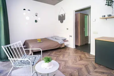 a bedroom with a bed and a table and chairs at House 22A Studio Apartments in Kaunas