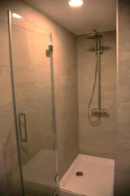 a shower with a glass door in a bathroom at Baltas gandras in Naisiai
