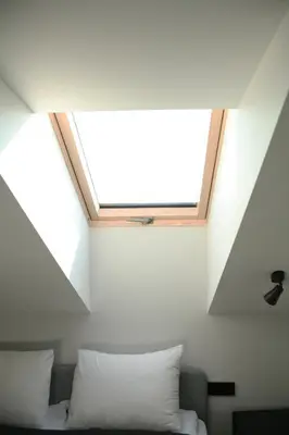 a skylight in a room with a couch and a window at Baltas gandras in Naisiai