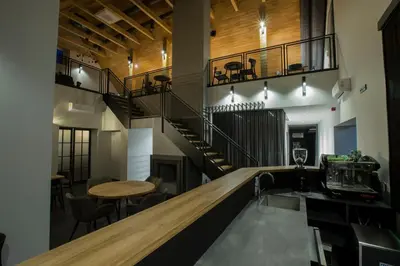 a bar in a restaurant with a spiral staircase at Baltas gandras in Naisiai