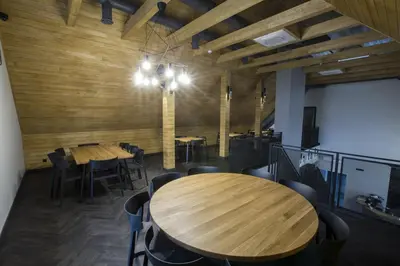 a dining room with wooden walls and tables and chairs at Baltas gandras in Naisiai