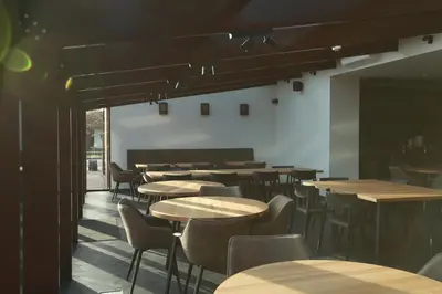 a restaurant with tables and chairs in a room at Baltas gandras in Naisiai