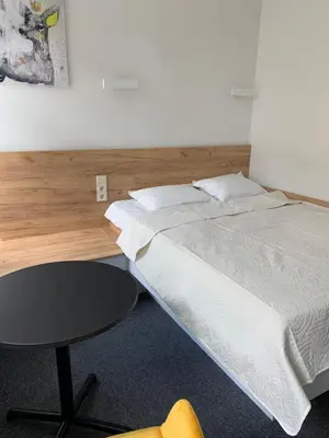 a bedroom with a bed and a table in it at River house apartments in Kaunas
