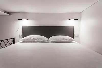 a bedroom with a white bed with two pillows at River house apartments in Kaunas