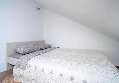 a bedroom with a bed with a white bedspread at House 22A Apartments in Kaunas