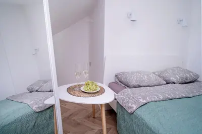 a room with two beds and a table with wine glasses at House 22A Apartments in Kaunas