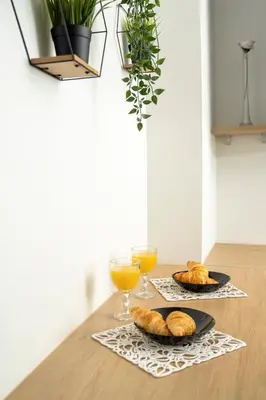 a table with two glasses of orange juice and croissants at House 22A Apartments in Kaunas