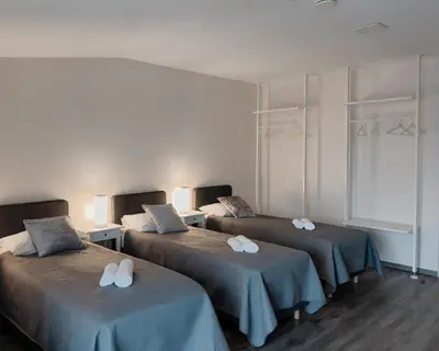 a room with three beds with towels on them at Svečių namai Žara in Tytuvėnai