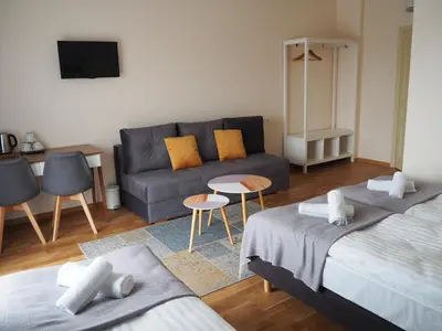 a living room with two beds and a couch at Svečių namai Žara in Tytuvėnai