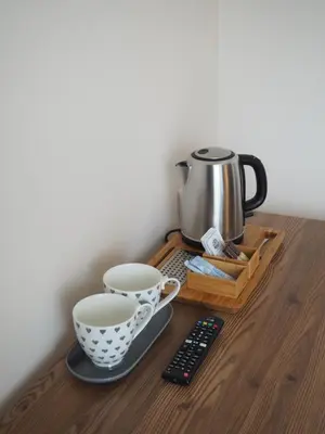 a coffee maker and two cups on a wooden table at Svečių namai Žara in Tytuvėnai