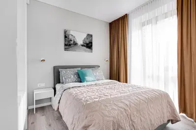 a white bedroom with a bed and a window at #stayhere - Central Castle View Riverside Apartment in Vilnius
