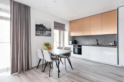 a kitchen and dining room with a table and chairs at #stayhere - Central Castle View Riverside Apartment in Vilnius