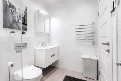 a white bathroom with a toilet and a sink at #stayhere - Central Castle View Riverside Apartment in Vilnius