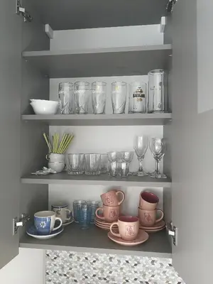a cupboard filled with lots of dishes and glasses at Central Apartments Nojus in Druskininkai