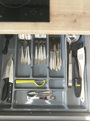 a drawer filled with utensils in a cabinet at Central Apartments Nojus in Druskininkai