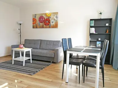 a living room with a table and a couch at Šiauliai Central Apartment @ Trakų street in Šiauliai