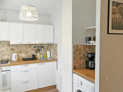 a kitchen with white cabinets and a sink at Šiauliai Central Apartment @ Trakų street in Šiauliai