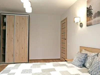 a bedroom with a king sized bed and a closet at Šiauliai Central Apartment @ Trakų street in Šiauliai