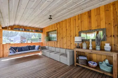 a living room with a couch on a wooden deck at Vila LATO, Druskininkai in Latežeris