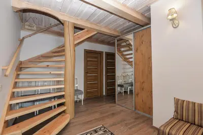 a staircase in a living room with wooden floors and wooden ceilings at Vila LATO, Druskininkai in Latežeris