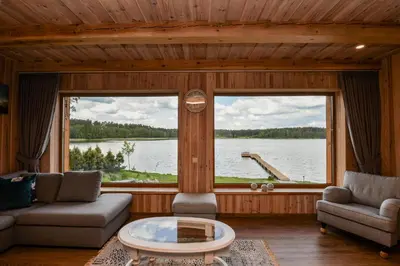 a living room with two couches and a large window at Vila LATO, Druskininkai in Latežeris