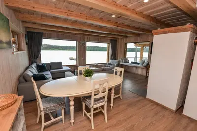 a dining room and living room with a table and chairs at Vila LATO, Druskininkai in Latežeris